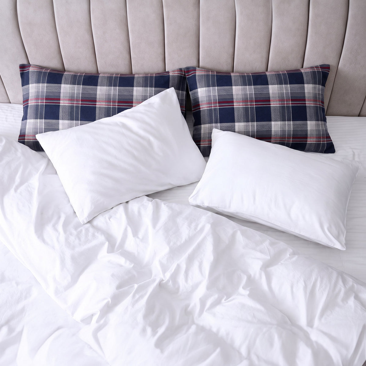 Bett von oben mit zwei Kissen im Flanellbezug in Blau Kariert und zwei weißen Kissen
