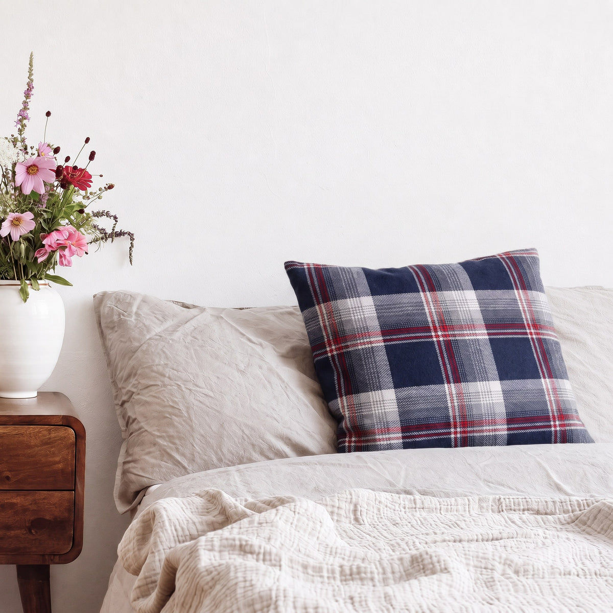 Kissen mit Flanellbezug in Blau Kariert auf einem Bett neben einem Nachttisch mit Blumen